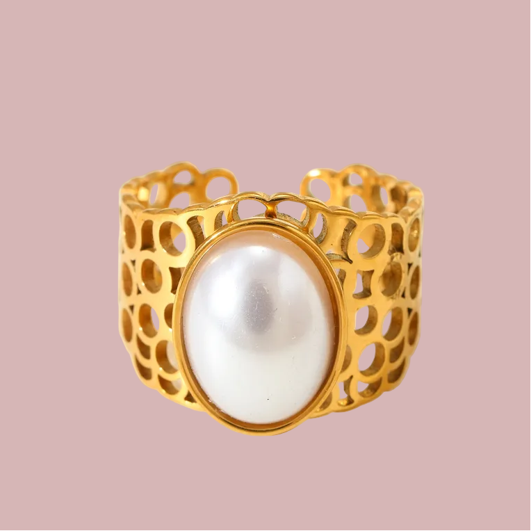 Gold bracelet with a pearl on a pink background