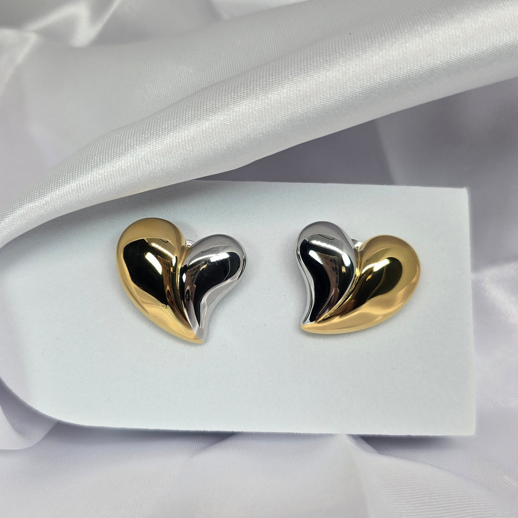 Heart-shaped earrings on a white card with a white fabric background