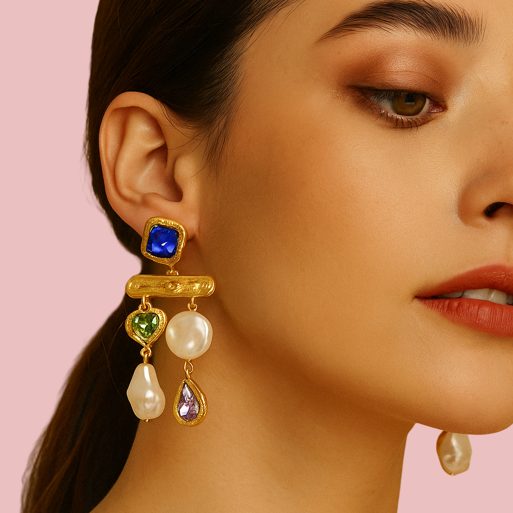 Close-up of a woman wearing a gold earring with colored gemstones and pearls.