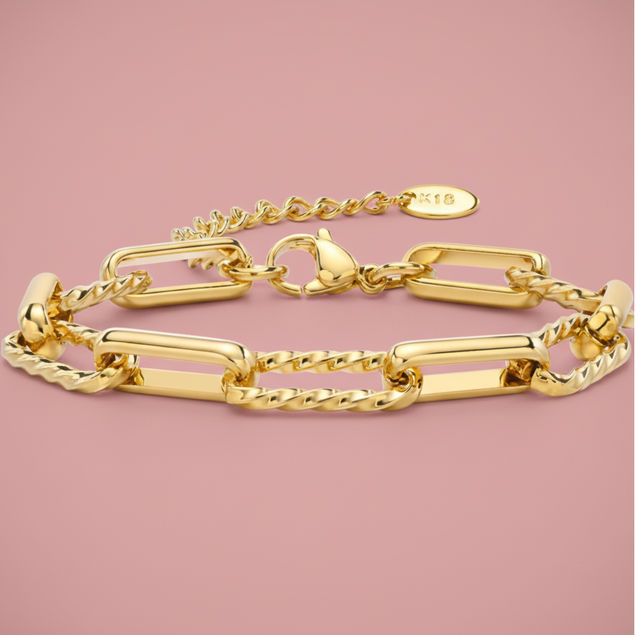 Gold chain bracelet on a pink background