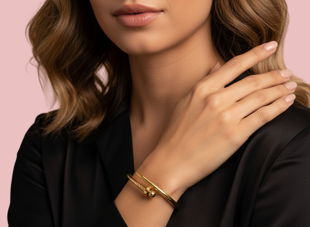 Woman wearing a gold bracelet on a beige background