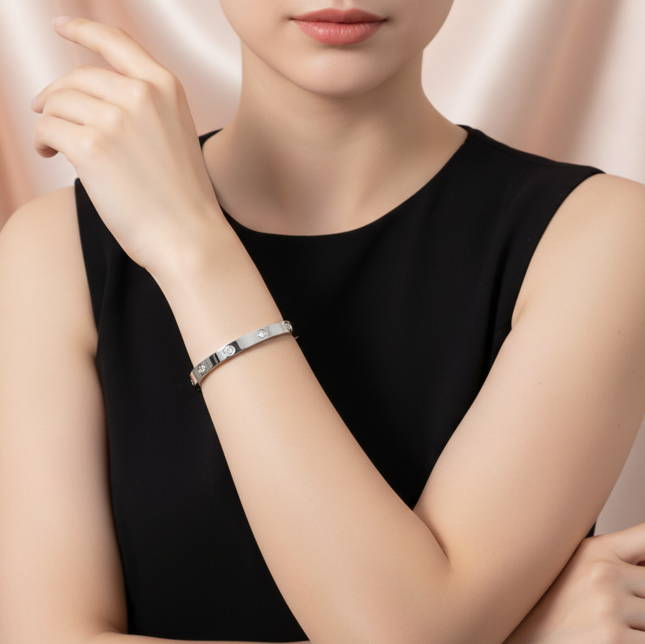 Woman wearing a silver bracelet on a plain background