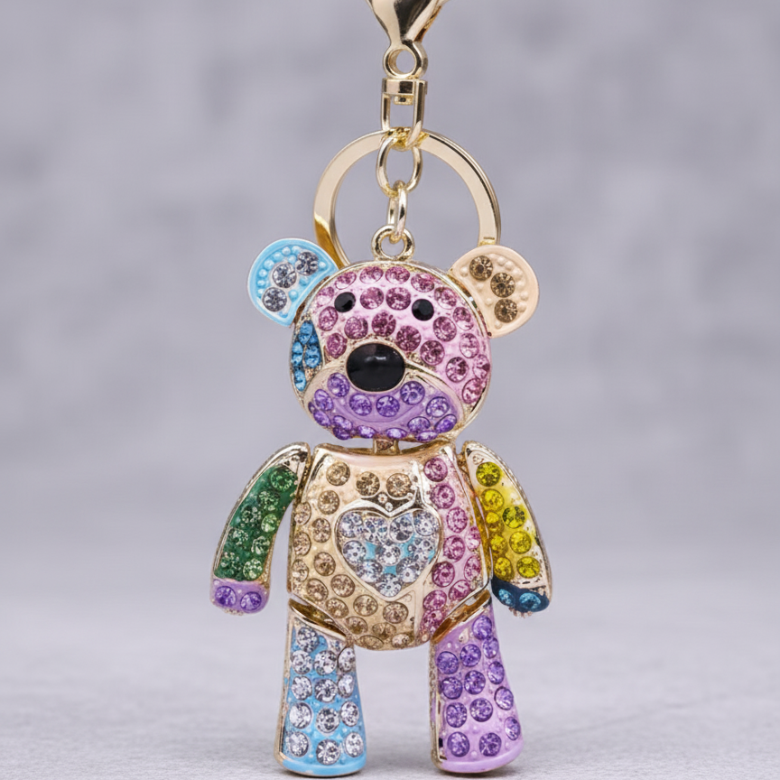 Colorful teddy bear keychain with rhinestones on a gray background
