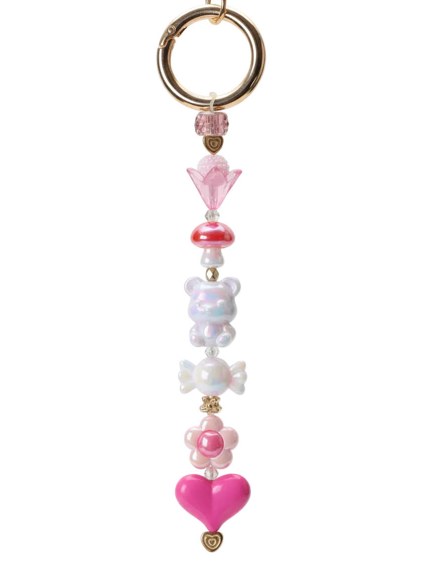 Decorative keychain with pink heart, flower, and beaded design on a white background