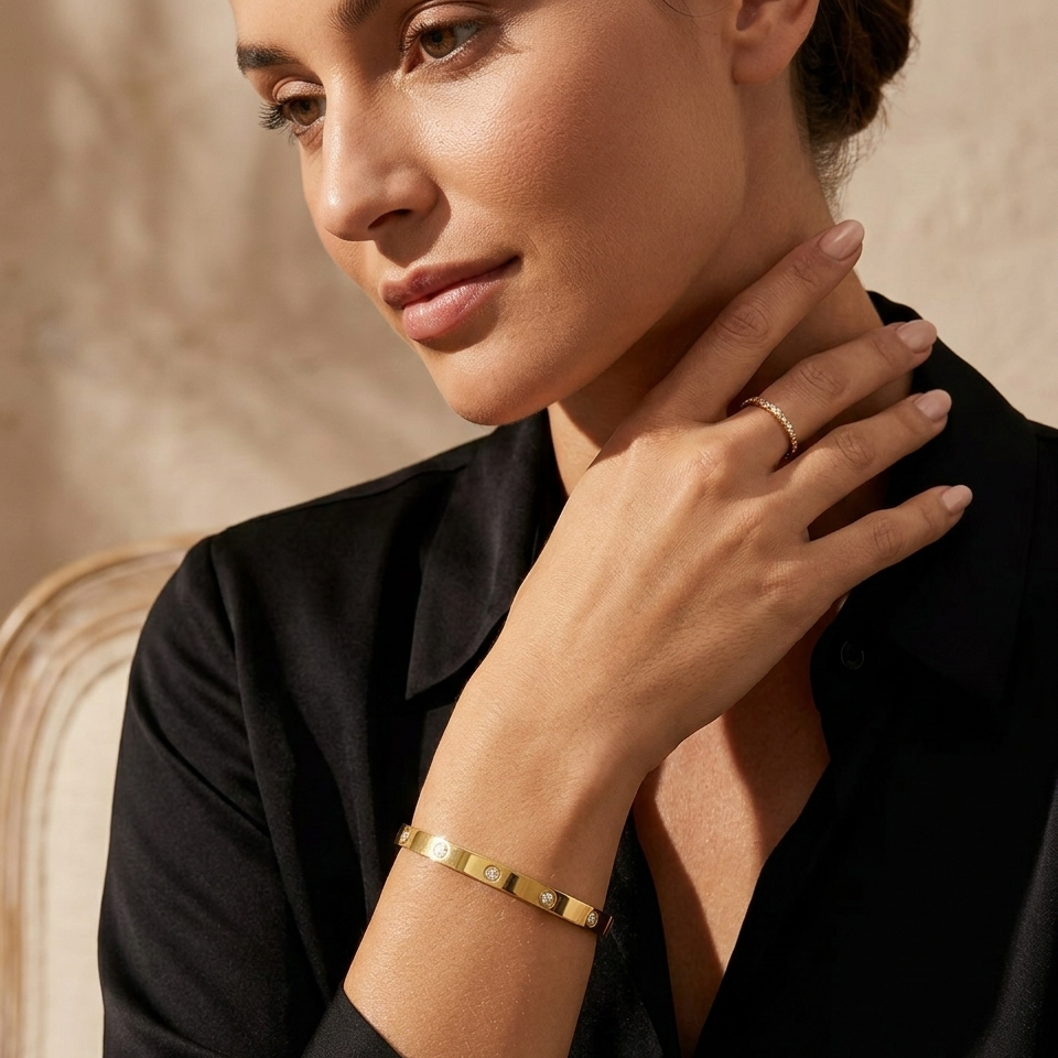 Woman wearing gold jewelry with a neutral background