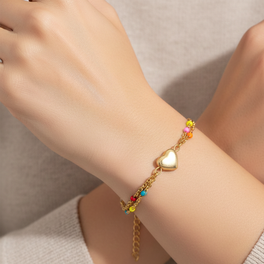 Bracelet with heart charm and colorful beads on a wrist against a neutral background