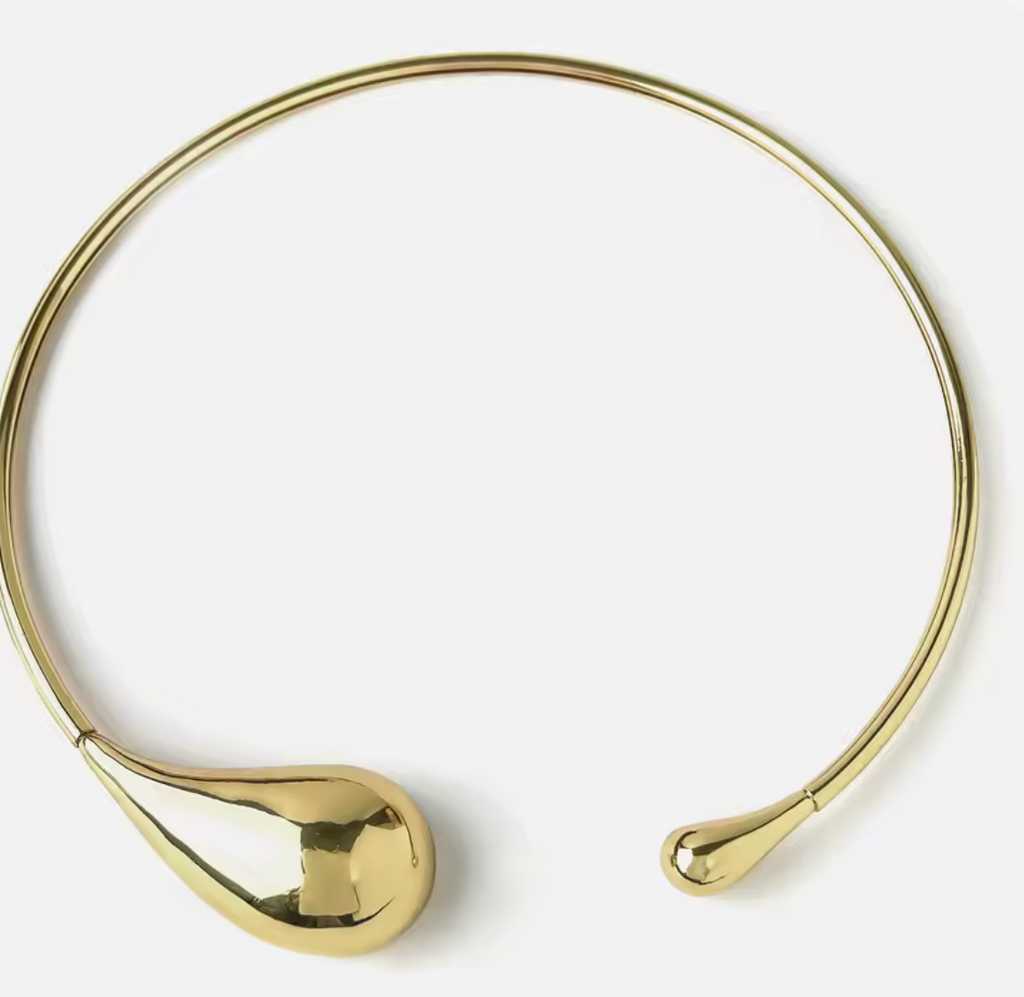 Gold choker necklace on a white background