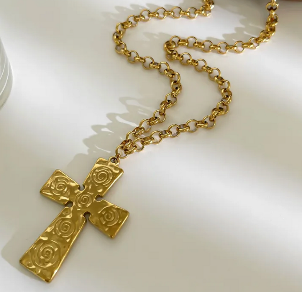 Gold cross necklace on a white background