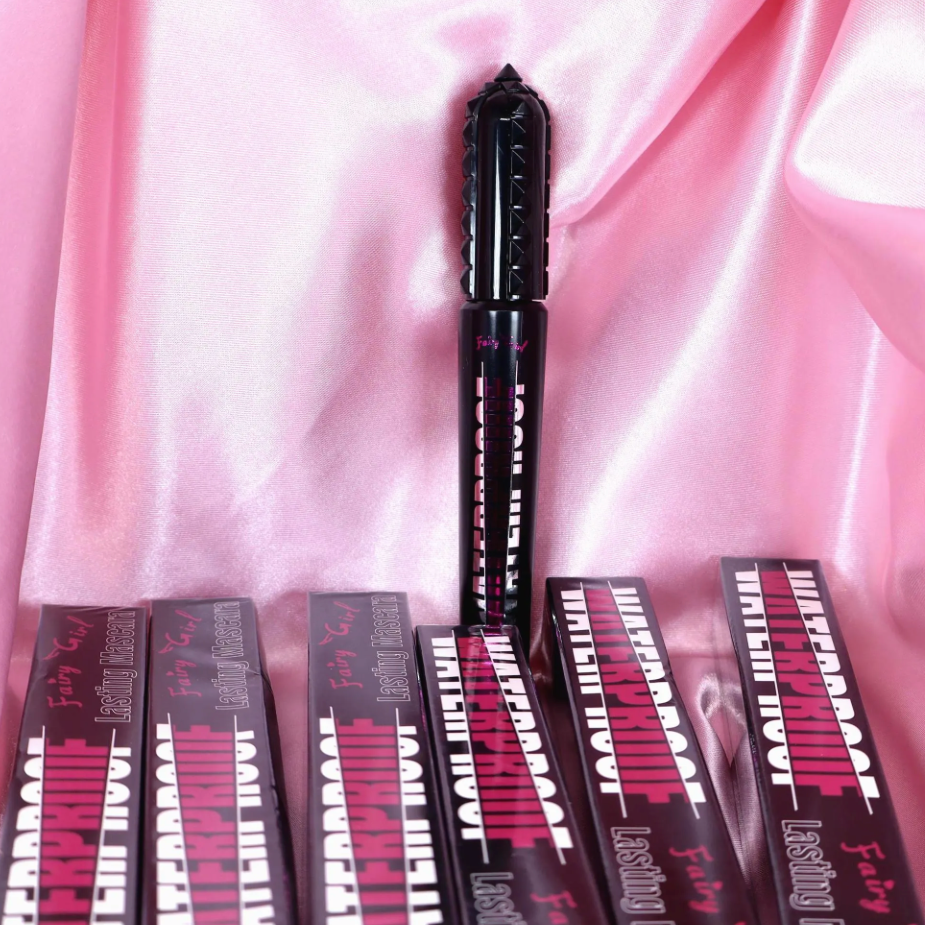 Black mascara with packaging on a pink fabric background
