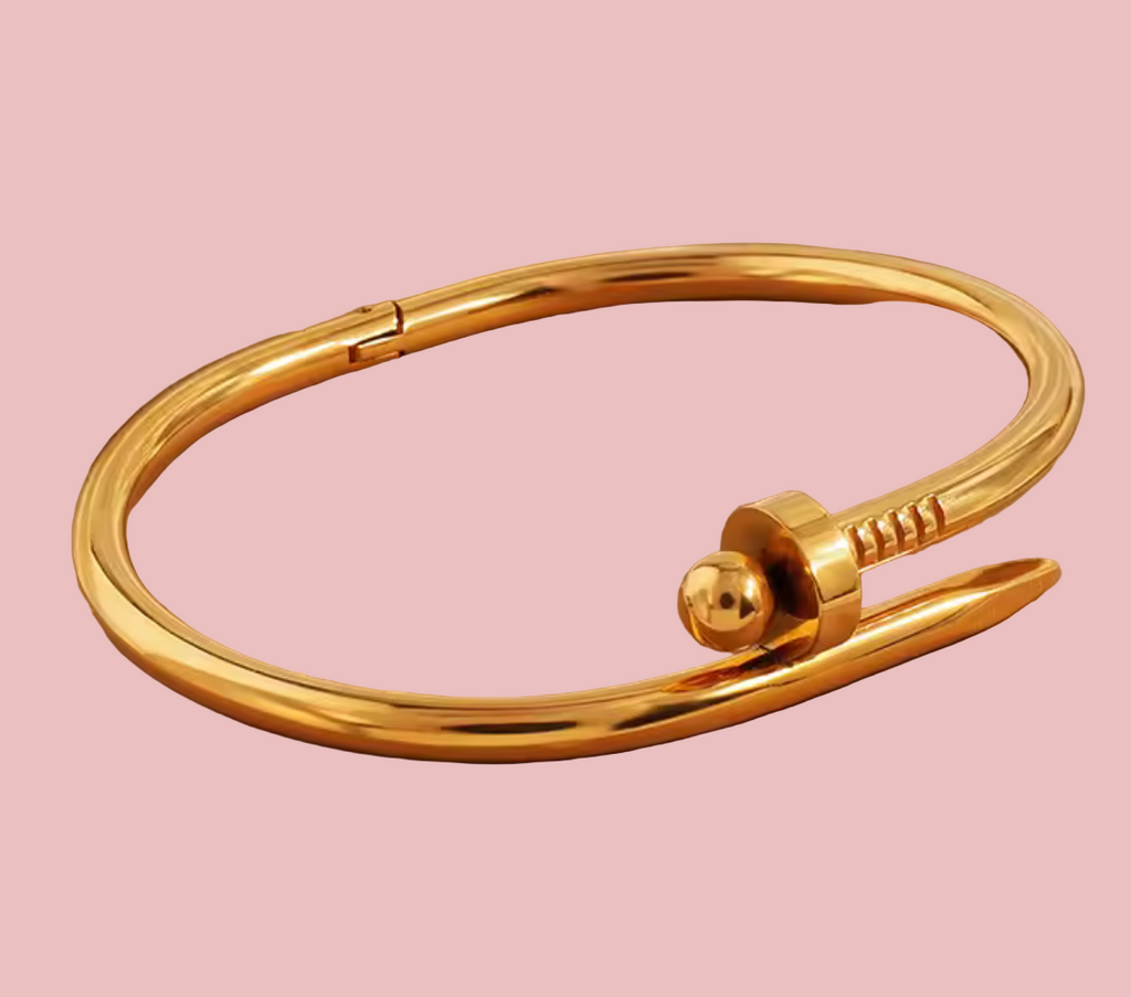 Gold bracelet on a beige surface