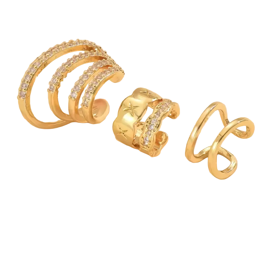 Set of gold ear cuffs with embedded stones on a beige background