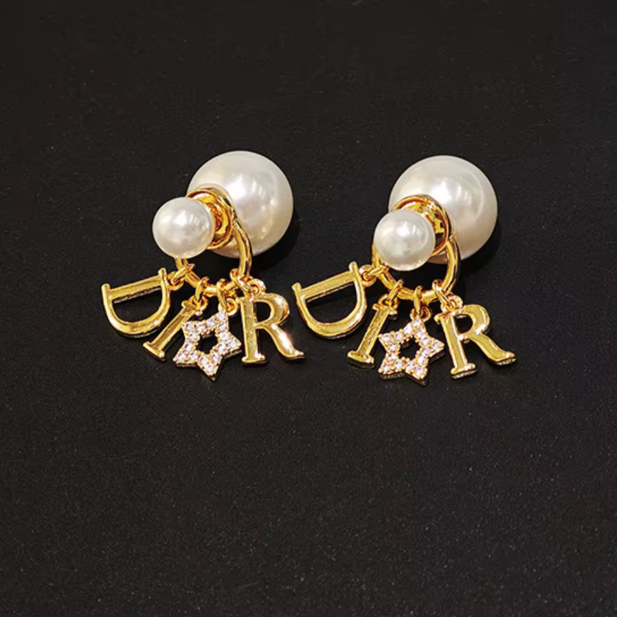Pair of earrings with pearls and 'Dior' charms on a black background