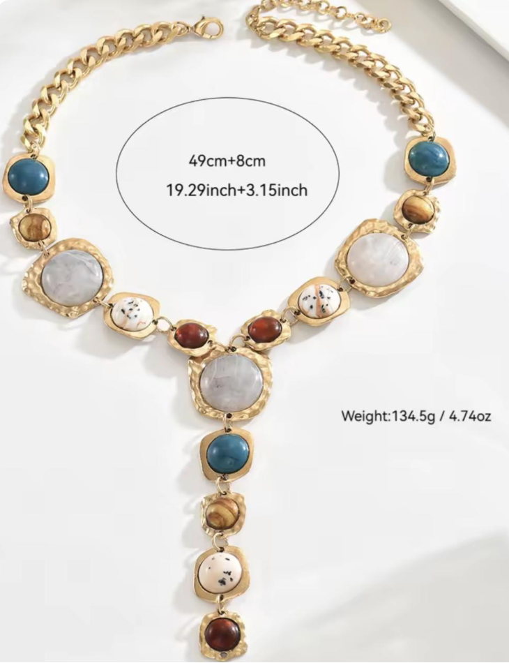 Necklace with multicolored stones and gold chain on a white background