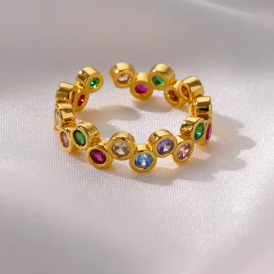 Gold ring with colorful gemstones on a white background