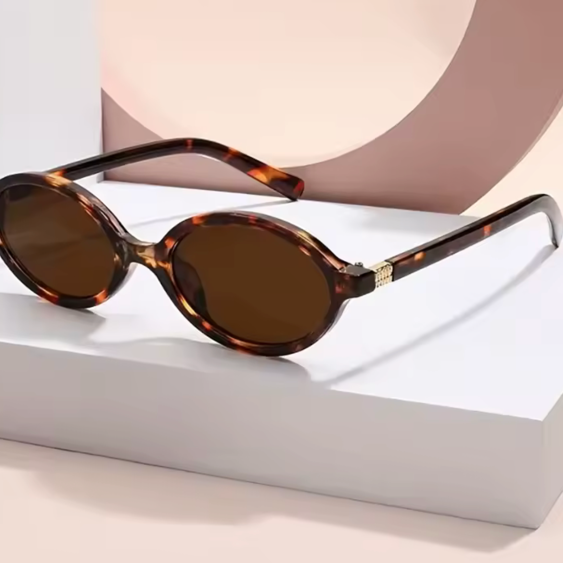 Sunglasses with tortoiseshell frame and brown lenses on a white surface