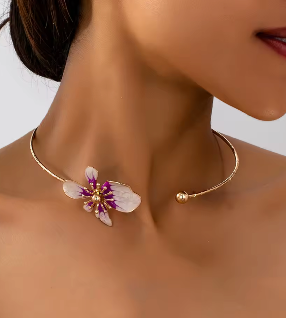 Gold necklace with a floral pendant worn by a model